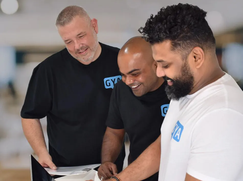Brett and Rowayne with a GYA team member reviewing work in the office